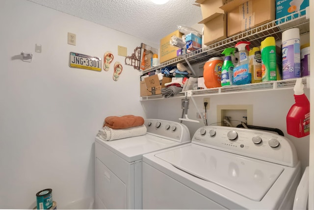 laundry room with a textured ceiling and separate washer and dryer