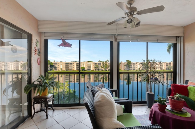 sunroom / solarium featuring plenty of natural light, ceiling fan, and a water view