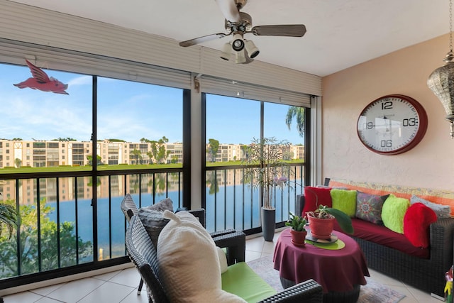 sunroom / solarium with a water view and ceiling fan