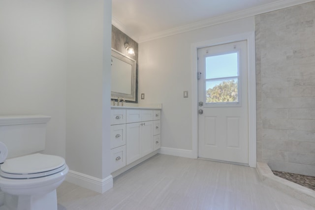 bathroom featuring vanity, toilet, ornamental molding, and tiled shower