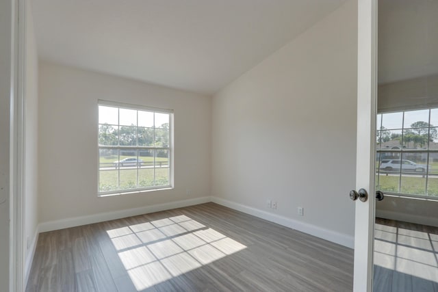 unfurnished room with wood-type flooring and lofted ceiling