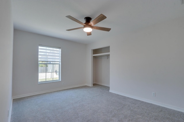 unfurnished bedroom featuring ceiling fan, a closet, and light carpet