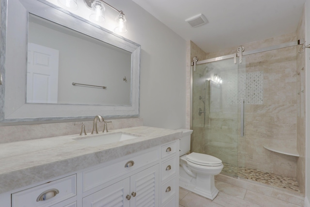 bathroom featuring tile patterned floors, vanity, toilet, and walk in shower