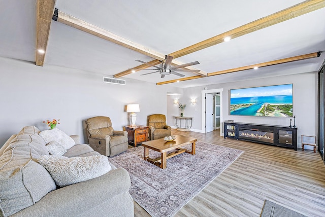 living room featuring beamed ceiling, ceiling fan, and hardwood / wood-style flooring