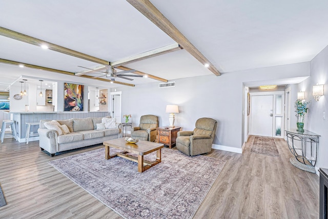 living room featuring ceiling fan, beamed ceiling, and light hardwood / wood-style floors