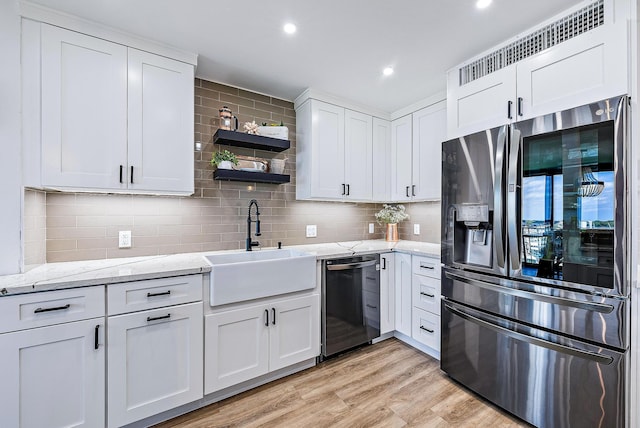 kitchen with dishwasher, sink, stainless steel refrigerator with ice dispenser, light wood-type flooring, and white cabinetry