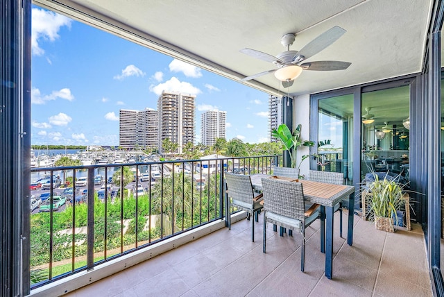 balcony featuring a water view and ceiling fan