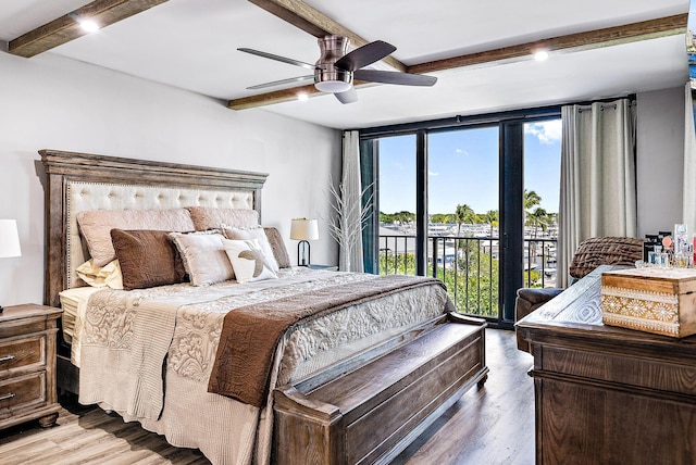 bedroom with beam ceiling, ceiling fan, a wall of windows, hardwood / wood-style floors, and access to outside