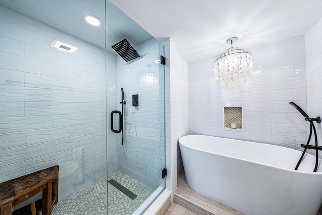 bathroom featuring a chandelier, independent shower and bath, and tile walls