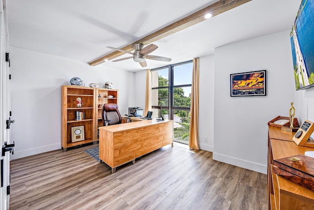 office area with beamed ceiling, ceiling fan, a wall of windows, and wood-type flooring