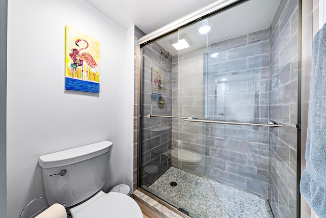 bathroom with toilet and a shower with shower door