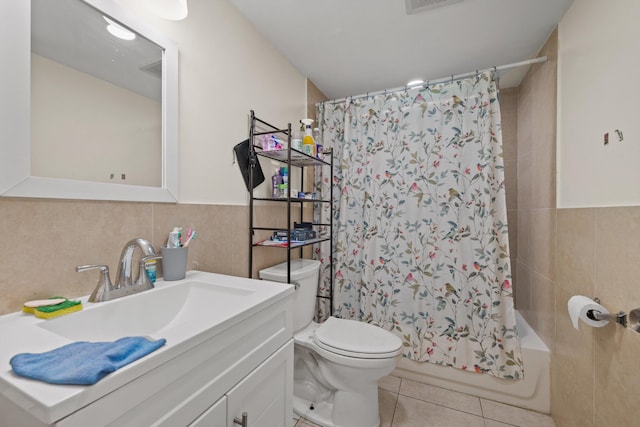 full bathroom with tile patterned floors, vanity, toilet, and tile walls