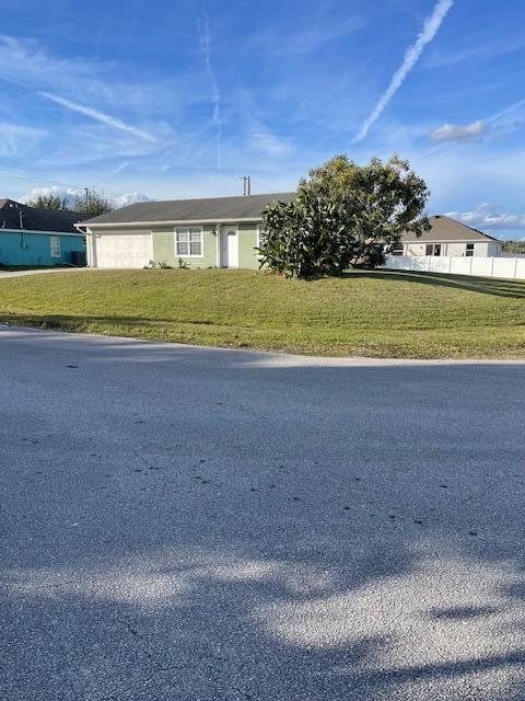 view of front of home with a front lawn and fence