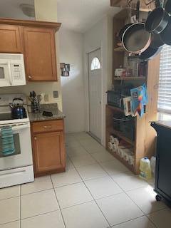 kitchen with white appliances and light tile patterned floors