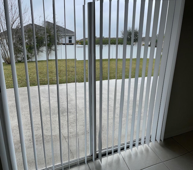 view of gate with a water view, a lawn, and a patio