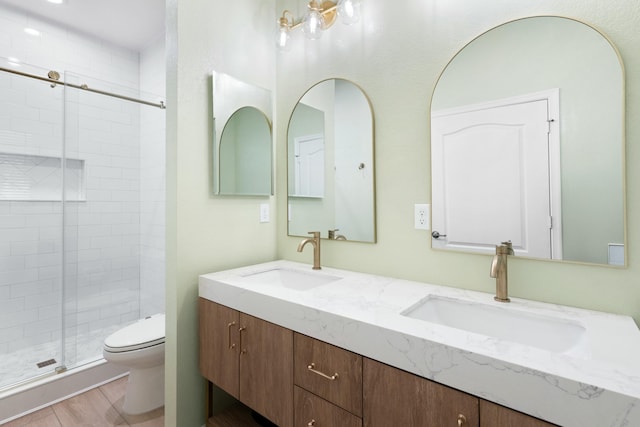 bathroom with hardwood / wood-style flooring, toilet, an enclosed shower, and vanity