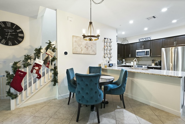 tiled dining area with a notable chandelier and sink