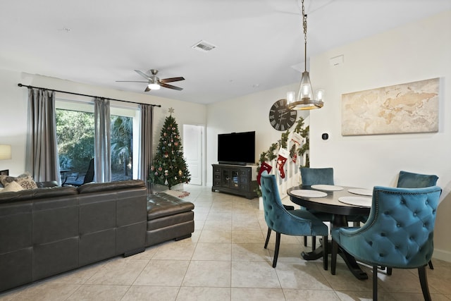 tiled dining room with ceiling fan with notable chandelier