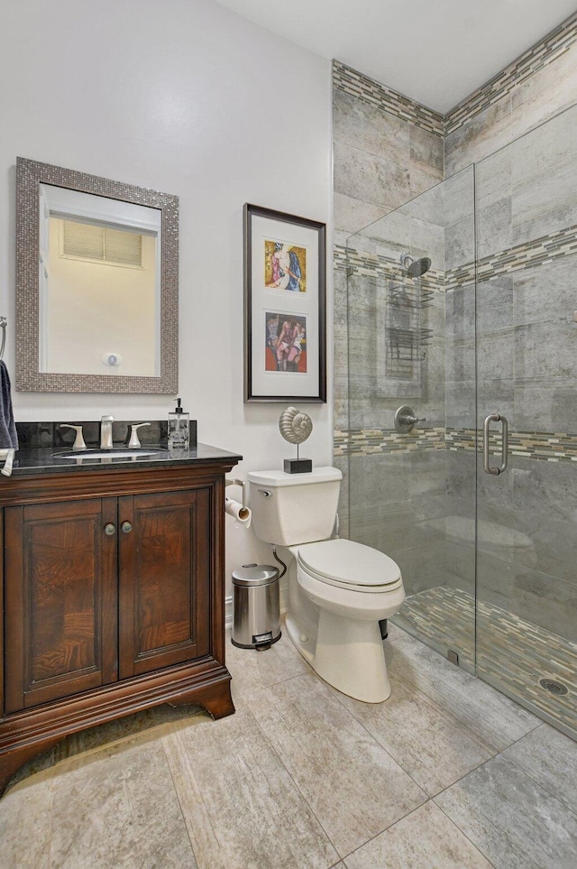 bathroom with vanity, toilet, tile patterned flooring, and walk in shower