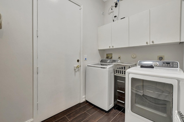 washroom with cabinets, dark hardwood / wood-style flooring, and washer and clothes dryer