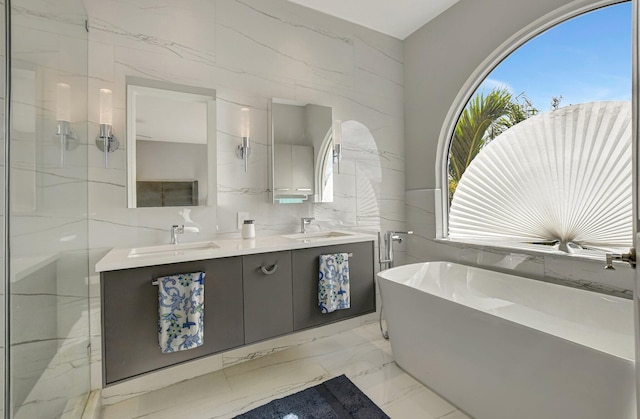 bathroom with shower with separate bathtub, vanity, and tile walls