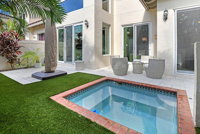 rear view of property with a jacuzzi, a yard, and a patio area