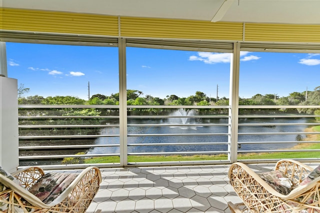 sunroom / solarium featuring a water view