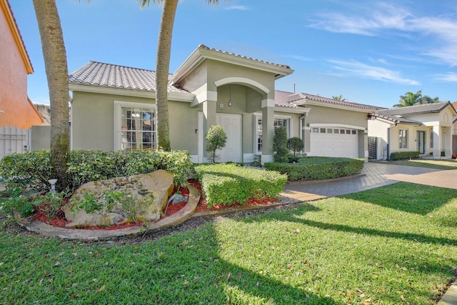 mediterranean / spanish-style home featuring a garage and a front lawn