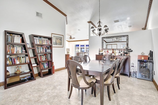 tiled dining room featuring lofted ceiling, ceiling fan with notable chandelier, crown molding, a textured ceiling, and beverage cooler