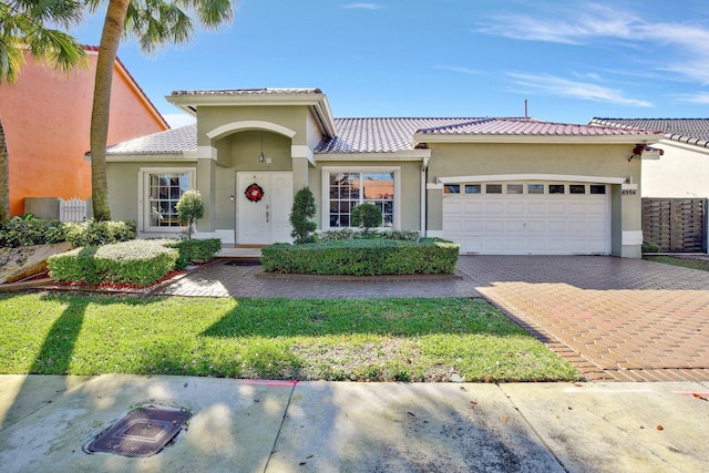 mediterranean / spanish home with a front lawn and a garage