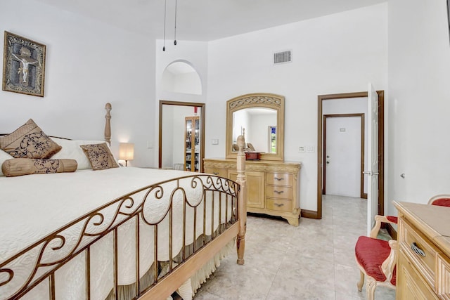 tiled bedroom featuring a towering ceiling