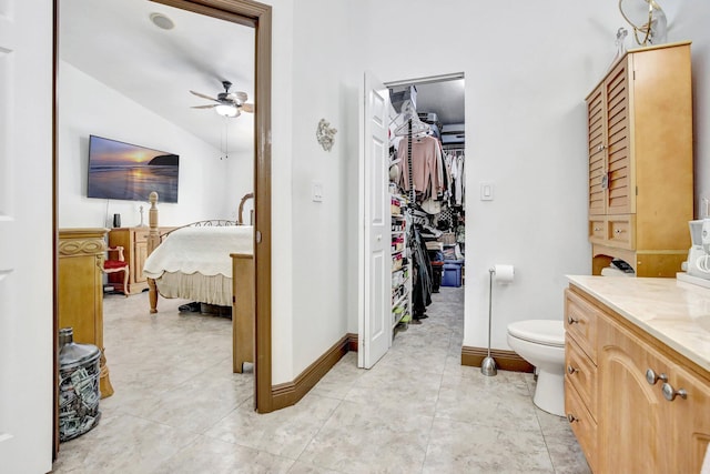 bathroom with vanity, lofted ceiling, tile patterned floors, ceiling fan, and toilet