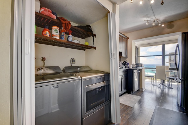 washroom with independent washer and dryer, dark hardwood / wood-style flooring, and a textured ceiling