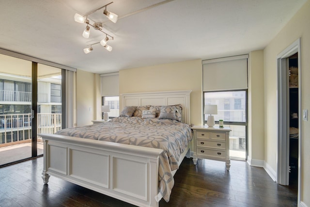 bedroom with expansive windows, dark wood-type flooring, and access to outside