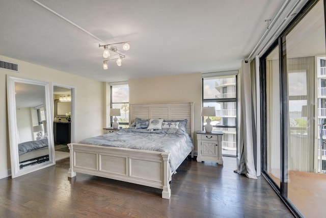 bedroom featuring multiple windows, dark wood-type flooring, and floor to ceiling windows