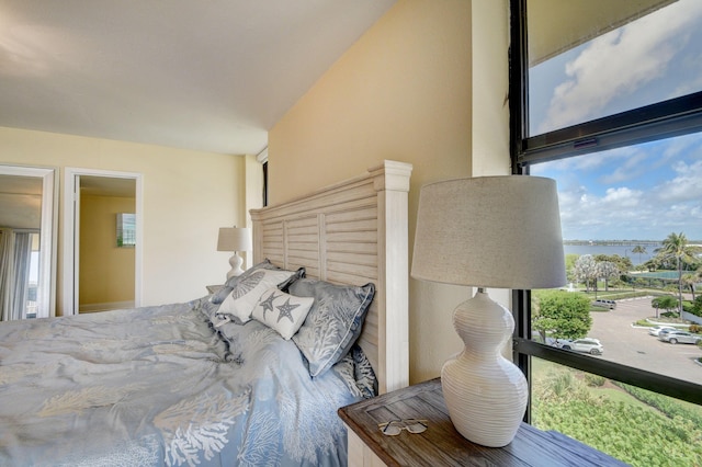 bedroom featuring multiple windows and a water view