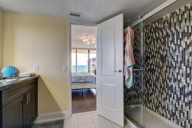 bathroom featuring tile patterned floors, vanity, enclosed tub / shower combo, and tasteful backsplash