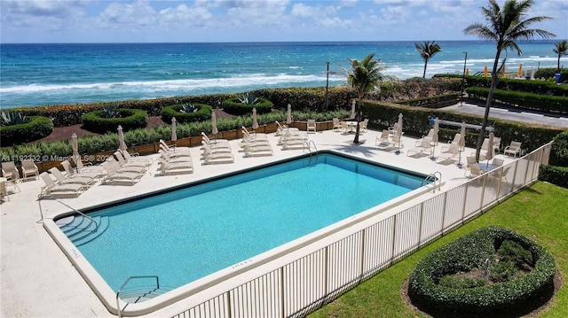 view of swimming pool with a patio area and a water view