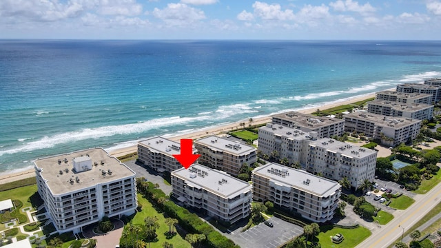 drone / aerial view featuring a beach view and a water view