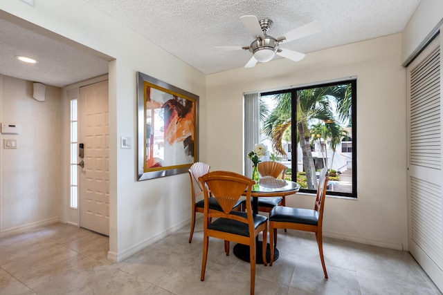 dining room featuring ceiling fan and a textured ceiling