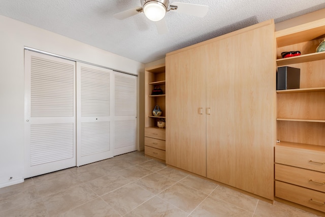 unfurnished bedroom with a textured ceiling and ceiling fan