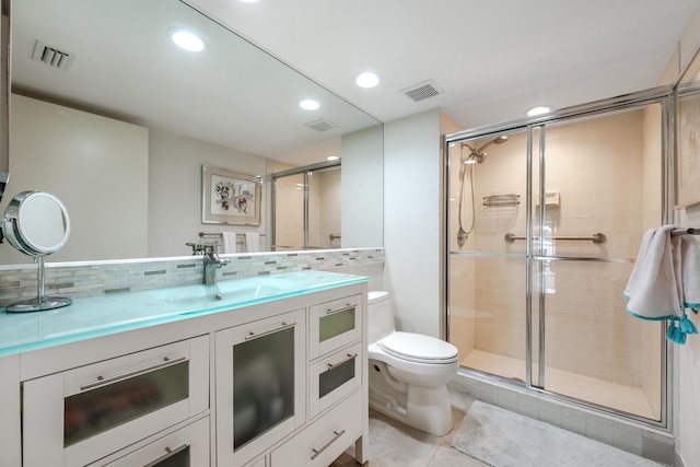 bathroom featuring an enclosed shower, vanity, and backsplash