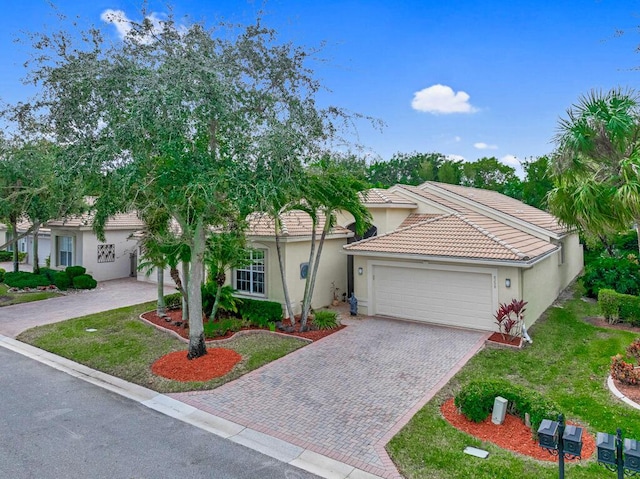 mediterranean / spanish-style house featuring a front yard and a garage