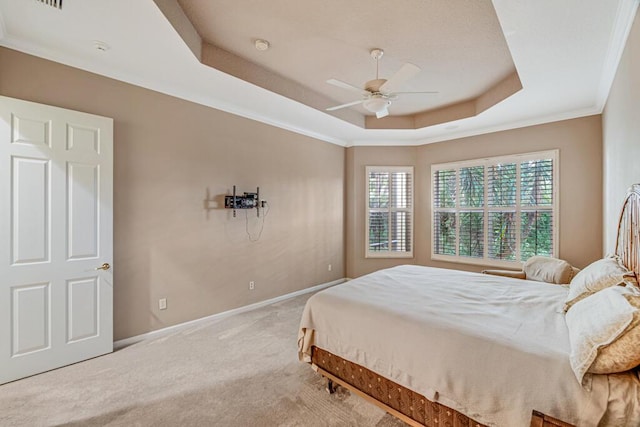 carpeted bedroom featuring ceiling fan and a tray ceiling