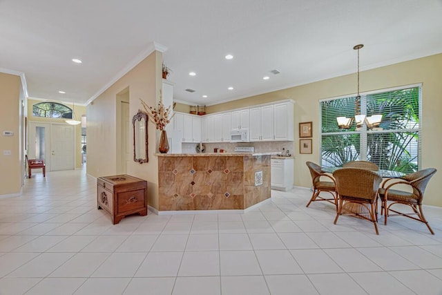 kitchen featuring light stone countertops, white cabinetry, tasteful backsplash, kitchen peninsula, and a chandelier