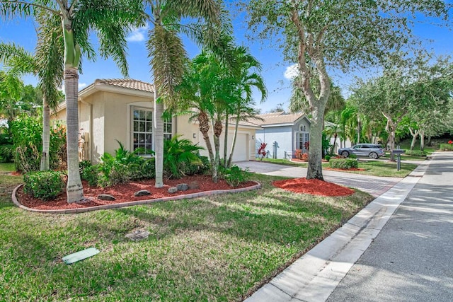 mediterranean / spanish house featuring a front yard and a garage