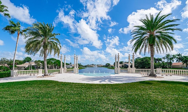 view of pool with a yard and a water view