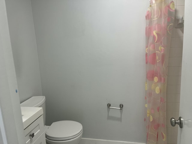 bathroom featuring vanity, toilet, and walk in shower