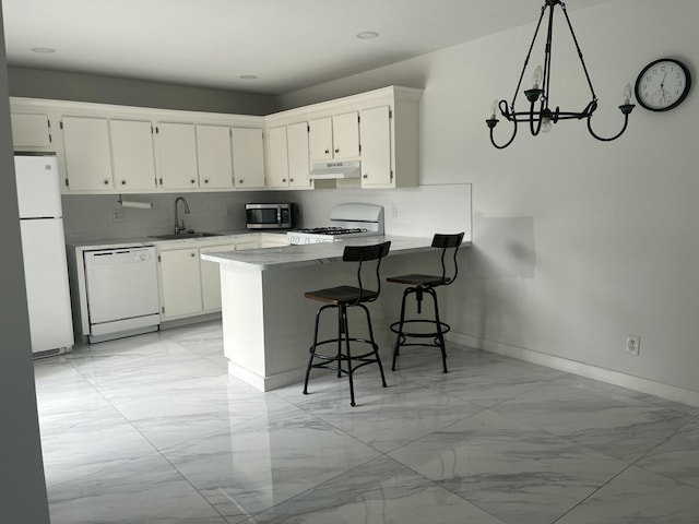 kitchen featuring kitchen peninsula, white appliances, sink, decorative light fixtures, and white cabinets