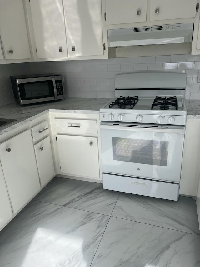 kitchen featuring white cabinetry, white gas range, and backsplash